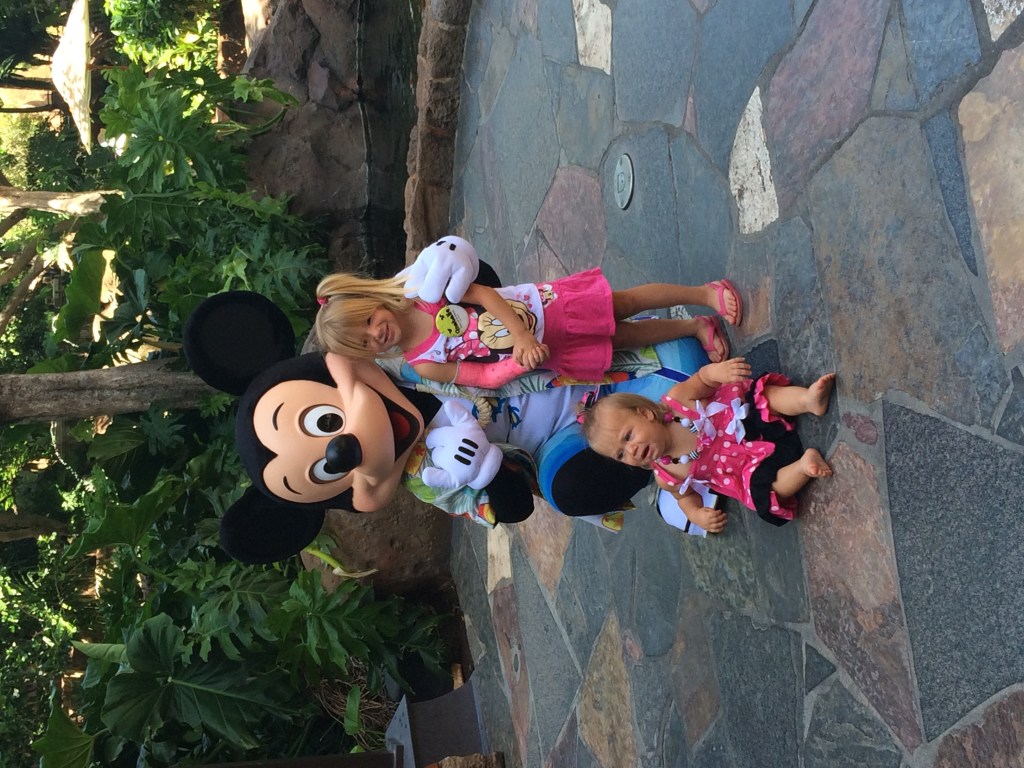 Two kids posing with Mickey Mouse at Aulani Resort in Ko'Olina. Posted on a travel guide that features the best things to do with kids on Oahu, Hawaii. 