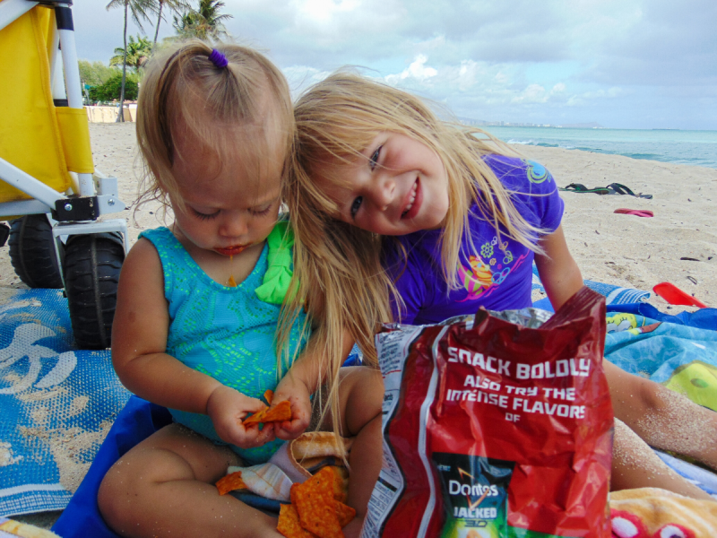 two girls snacking at the beach