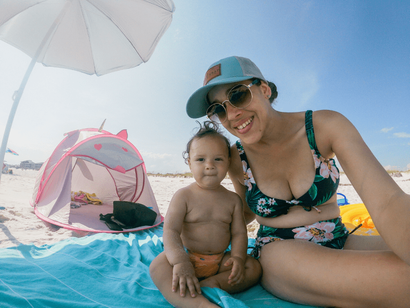 a mom and her son at the beach staying protected from the sun