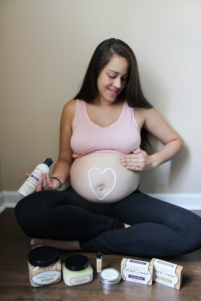 woman applying lotion to baby bump pregnancy belly