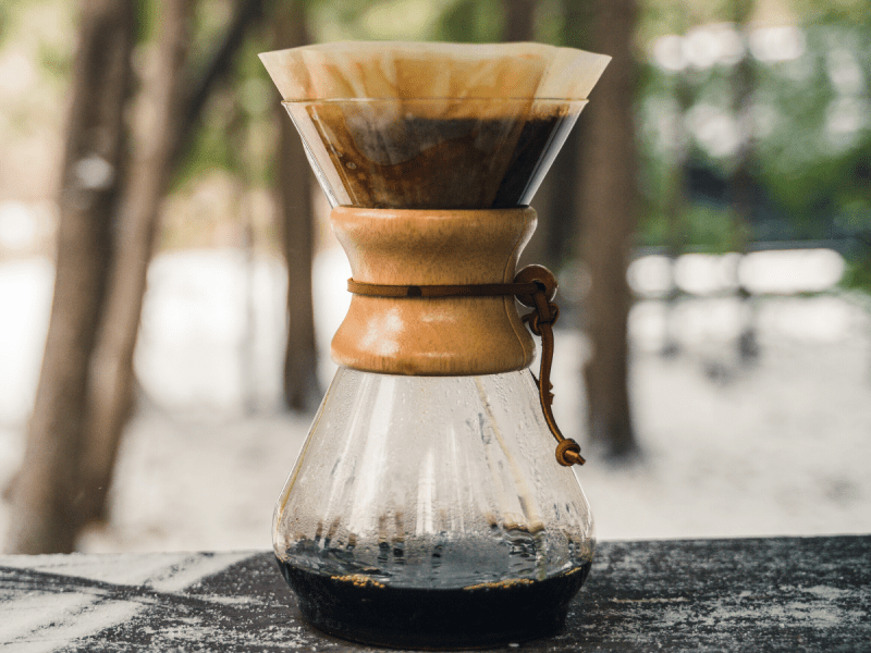 a pour over coffee maker on a picnic table for Brewing Coffee Outdoors