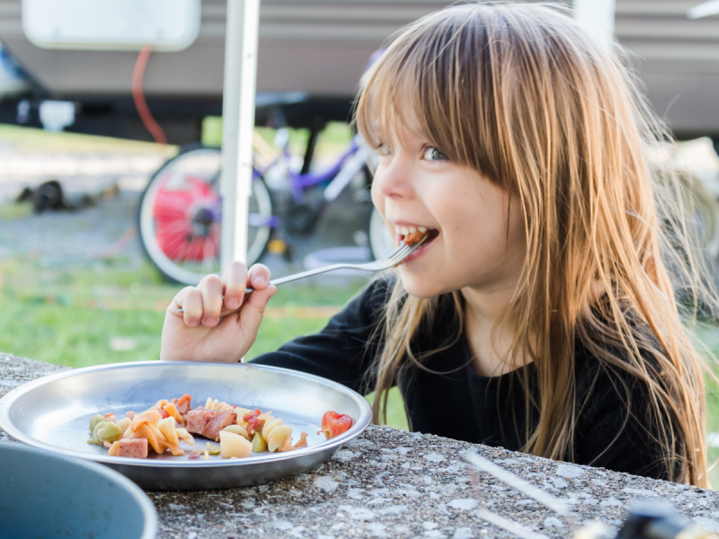 a girl eating food during a camping trip