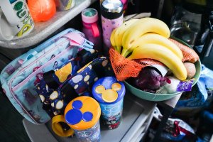 camper kitchen storage with lunchboxes, fruits, tumblers, and a coffee maker