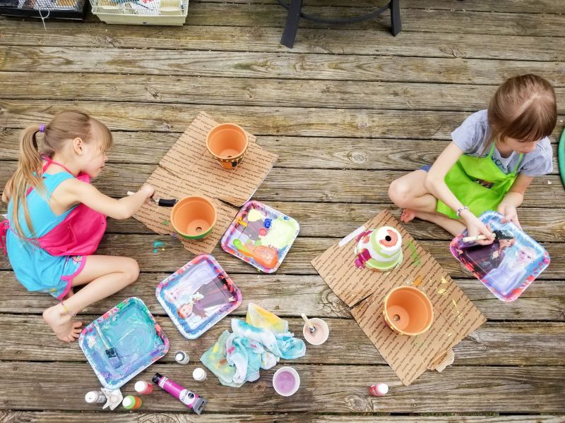 girls painting ceramic terra pots arts and crafts homeschool activity for kids spring