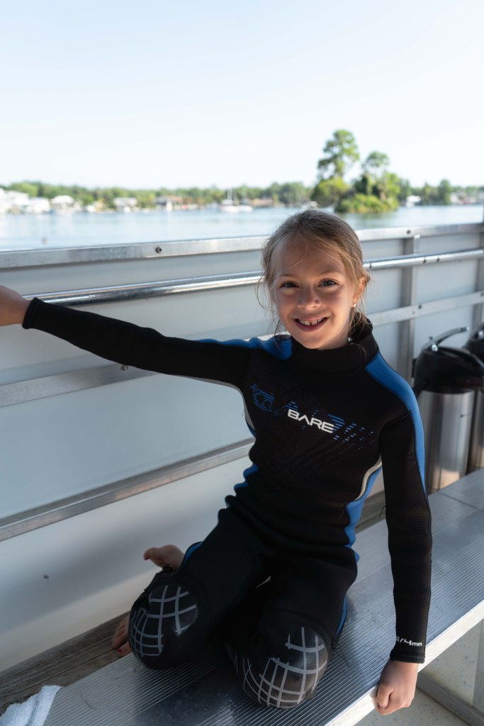 A girl in a wetsuit on a boat ready to go swimming with manatees with Adventure Center at Plantation on Crystal River. 