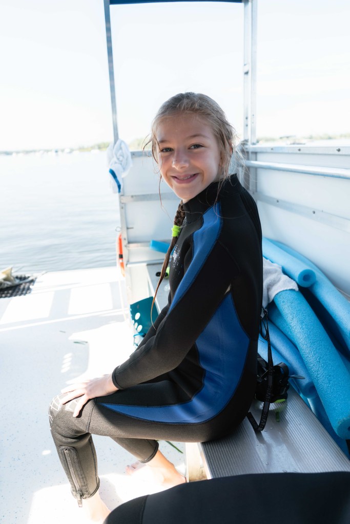 A girl in a wetsuit on a boat ready to go swimming with manatees with Adventure Center at Plantation on Crystal River. 