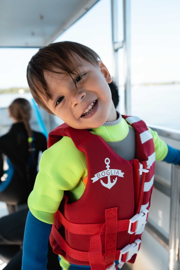 A boy in a wetsuit on a boat ready to go swimming with manatees with Adventure Center at Plantation on Crystal River. 