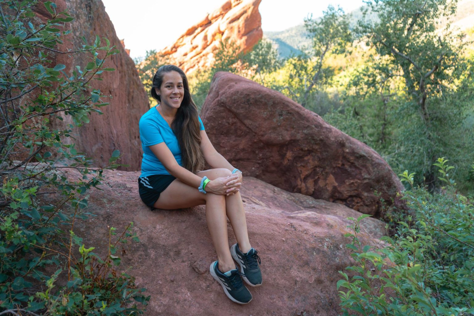 Woman (Jessica Tejera) sitting on a rock during a hike at Red Rocks Park in Morison close to Denver, Colorado.