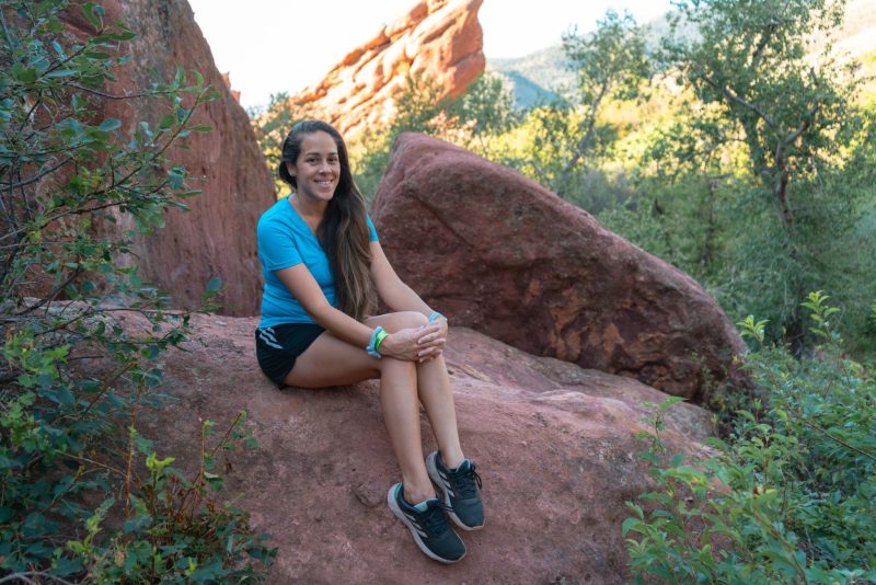 Woman (Jessica Tejera) sitting on a rock during a hike at Red Rocks Park in Morison close to Denver, Colorado.