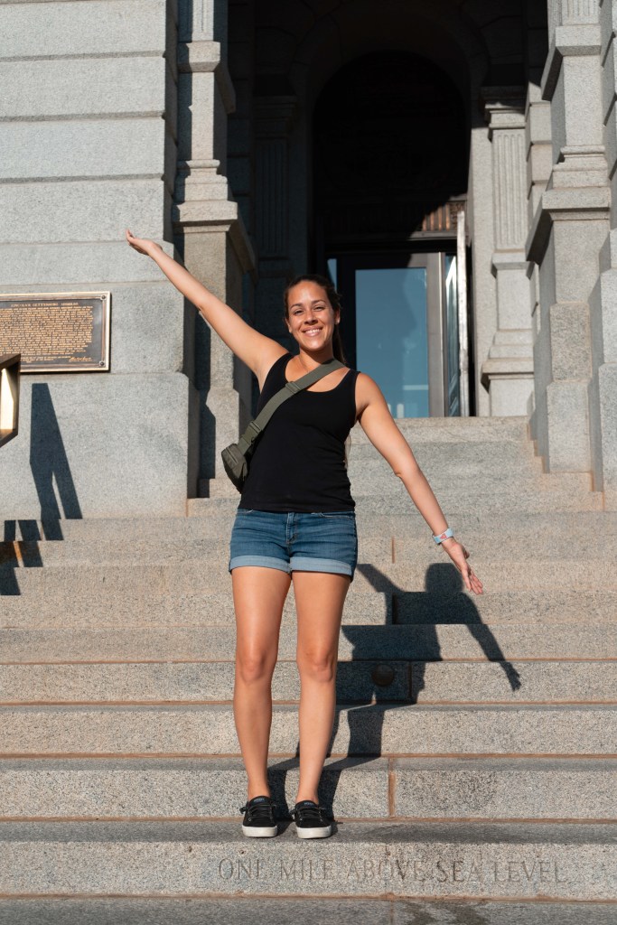 Woman standing on the mile high step in Denver, Colorado. 