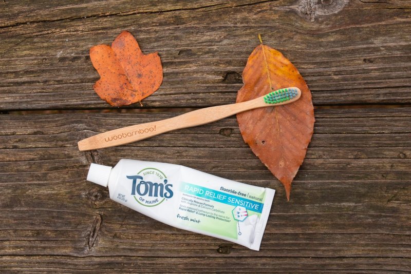 photo of a bamboo toothbrush and an eco-friendly toothpaste to use during your camping and backpacking trips. 