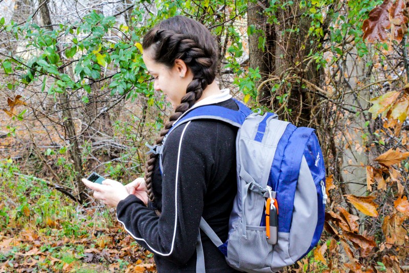 Woman using a GoTenna Mesh device to stay in touch with her family during their outdoor adventures such as camping and hiking. Posted on a camping guide talking about camping safety rules for kids follow. 