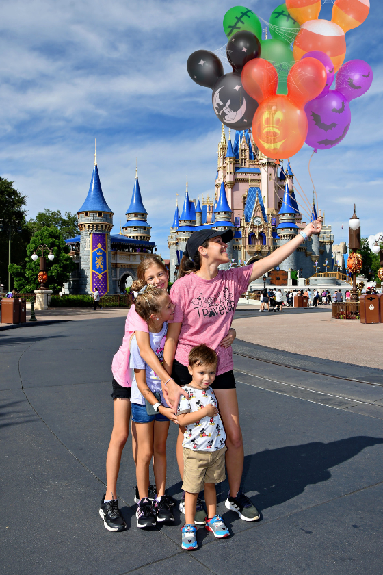 A mom and her 3 kids at Disney's Magic Kingdom park. Published on an article that teaches others how to become independent travel agents and how to travel more as a travel agent.