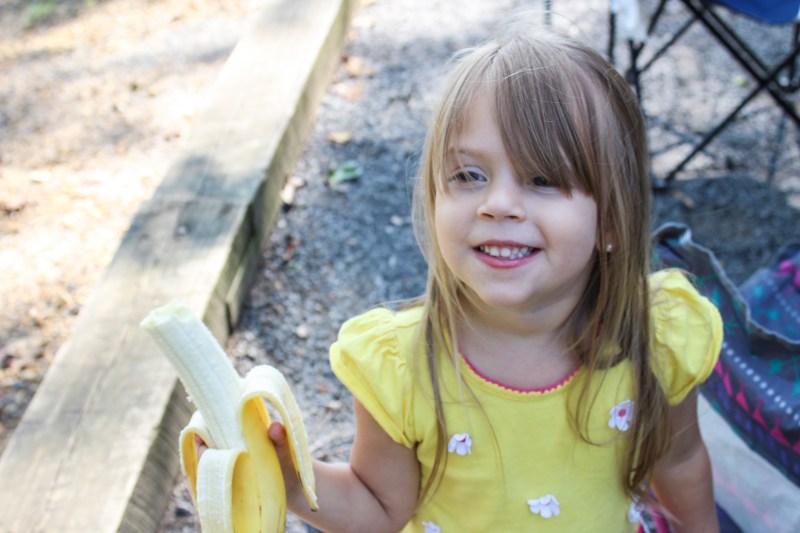 snacks hiking with kids girl eating a banana