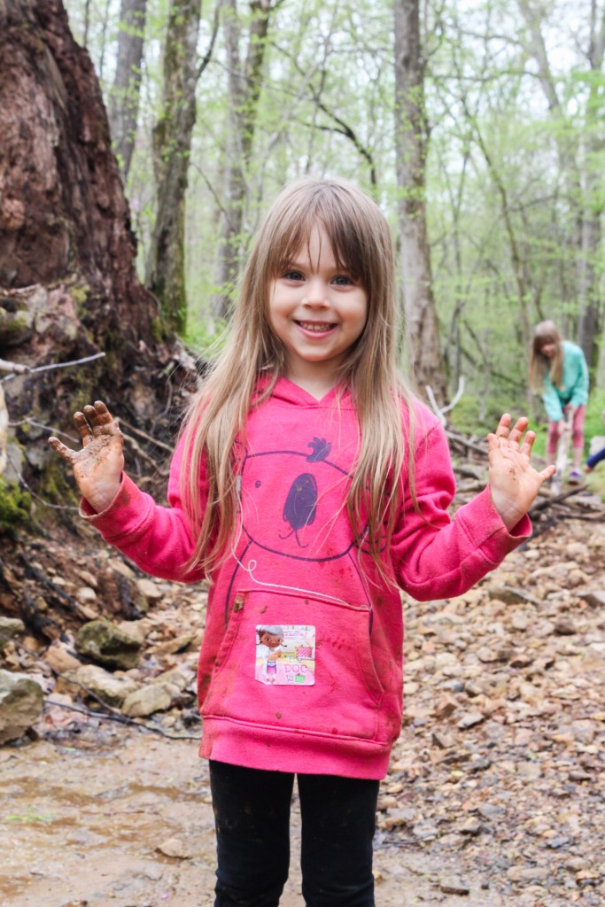 child with dirty hands muddy hiking with kids