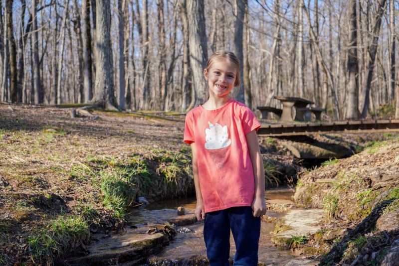 A girl standing by the water during at hike in Huntsville, Alabama