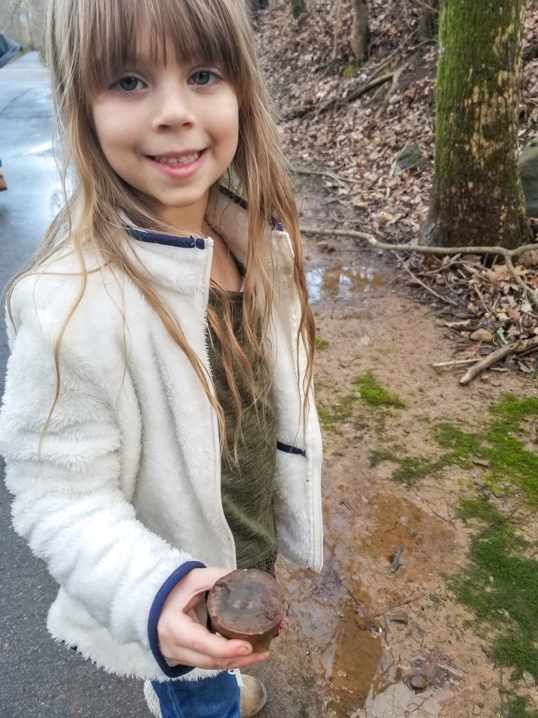 girl holding a rock at the park sensory play