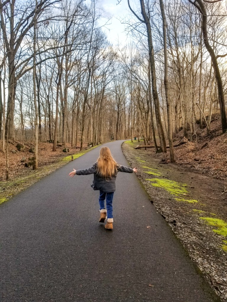 girl running outside playing outdoors nature's touch sensory play