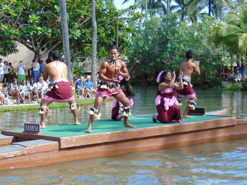 Samoan natives dancing cultural dances on a raft at the Polynesian Cultural Center. Posted on a travel guide that features the best things to do with kids on Oahu, Hawaii. 