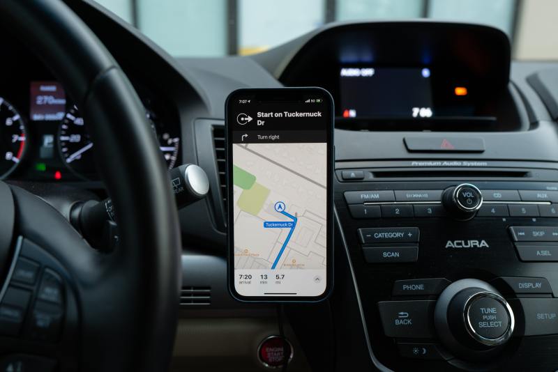 a phone with google maps on on the dashboard during a road trip