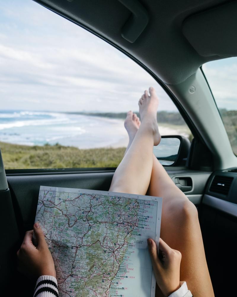 a woman in a car holding a map during a road trip with her family