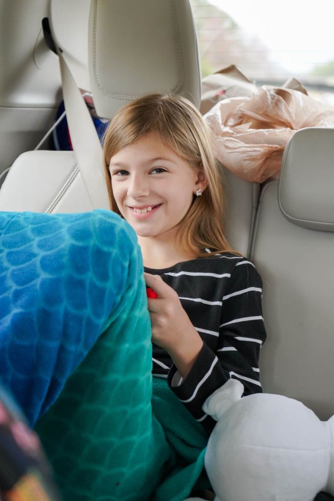 a girl playing on her tablet during a road trip