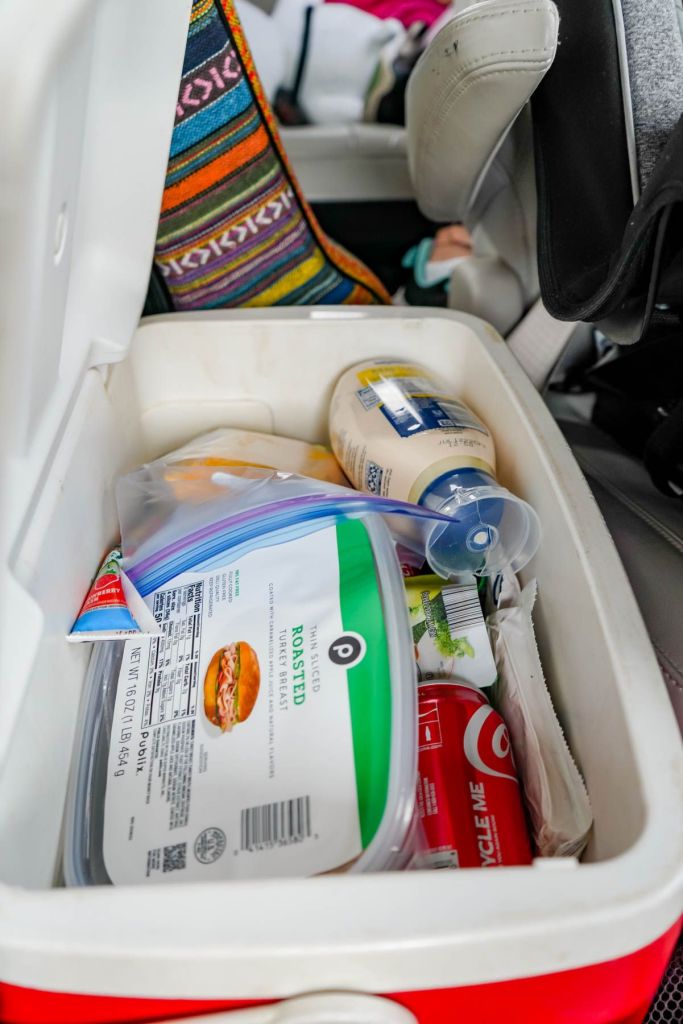 A cooler full of snacks for kids and food for a family road trip