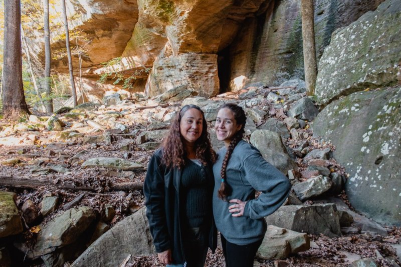 A mom and daughter hiking through Shawnee National Forest by the Natural Bridge hiking trail. 