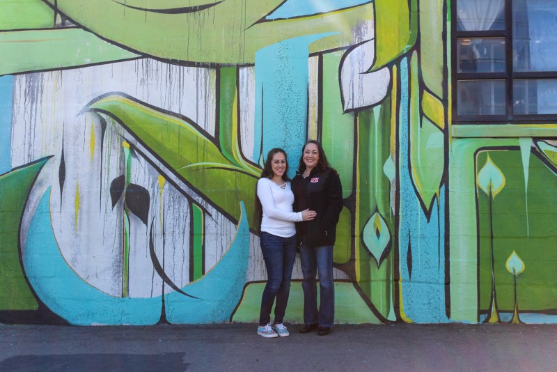 two women taking a picture at a mural at The Gulch neighborhood 