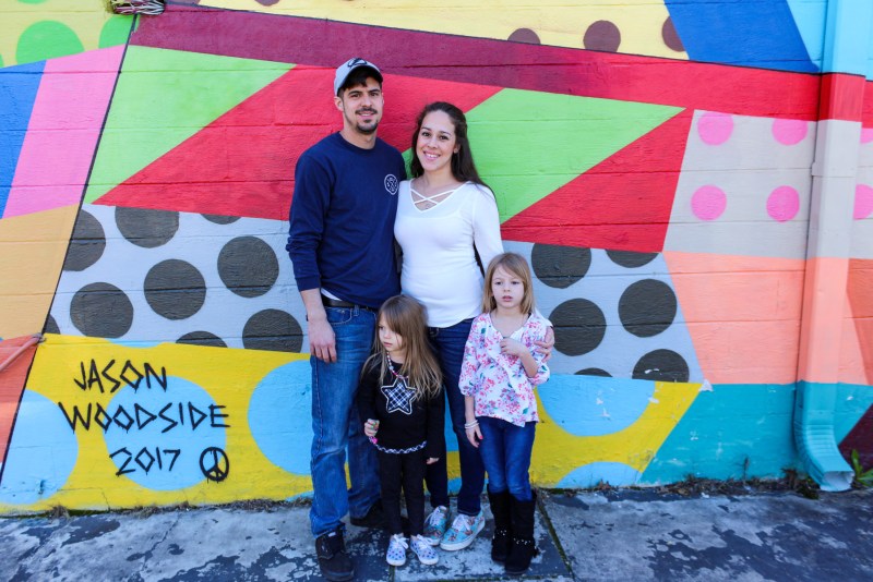 family taking a picture at a mural at The Gulch neighborhood 